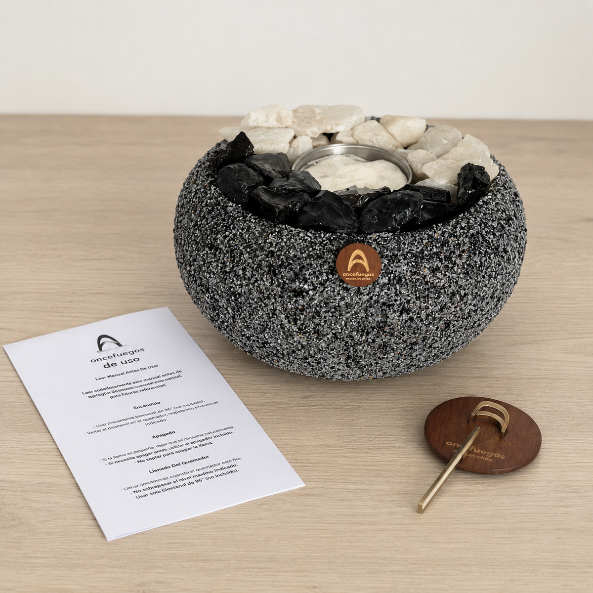Atacama Grande Cuarzo y Obsidiana con el manual de uso y el ahogador de llama sobre una mesa de madera