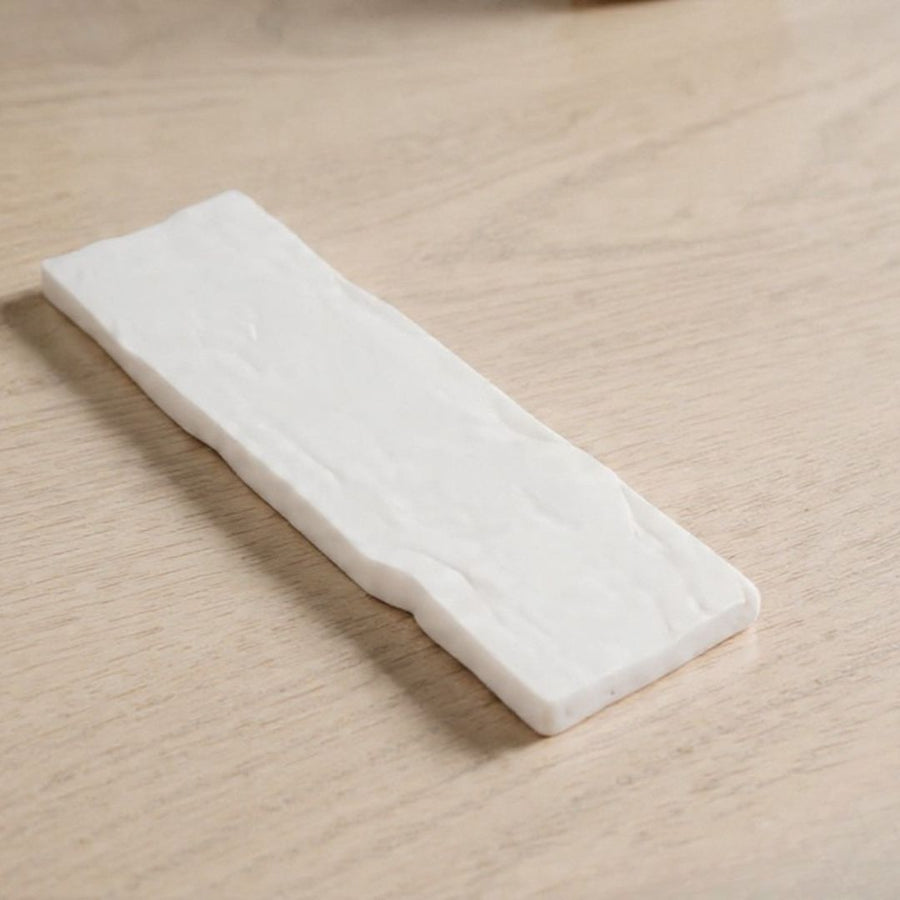 Tira de fibra blanca de repuesto para el quemador, sobre una superficie de madera clara