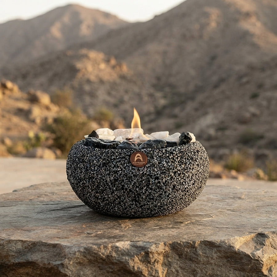 Fogón Atacama con cuarzo y obsidiana encendido sobre una roca, con cerros de fondo